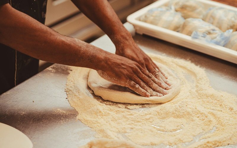 a person kneading dough on top of a table