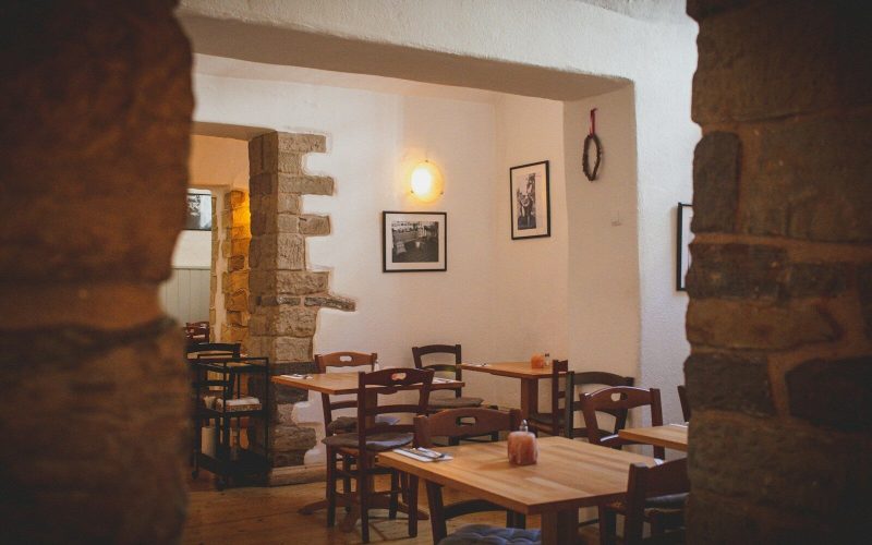 a restaurant with tables, chairs and pictures on the wall